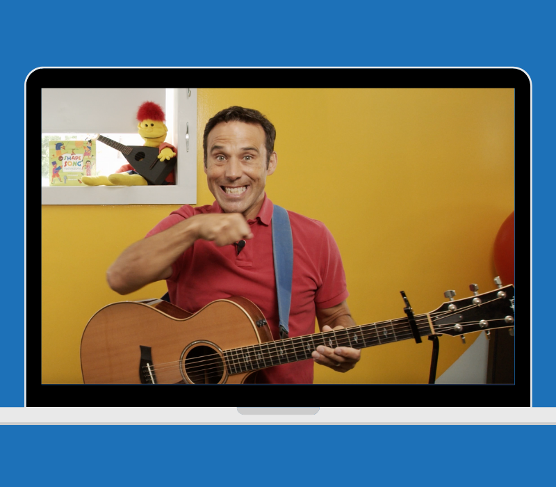 PBS Kids celebrity singing a song with his guitar for elementary music teachers on a Mac computer
