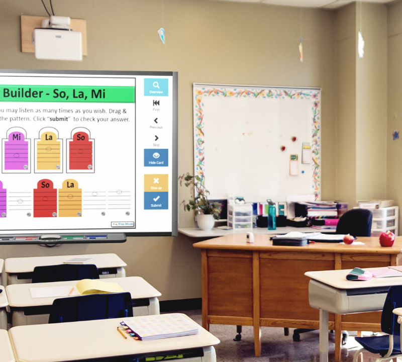 Empty classroom with a smart board showing Boom Cards music games in the classroom